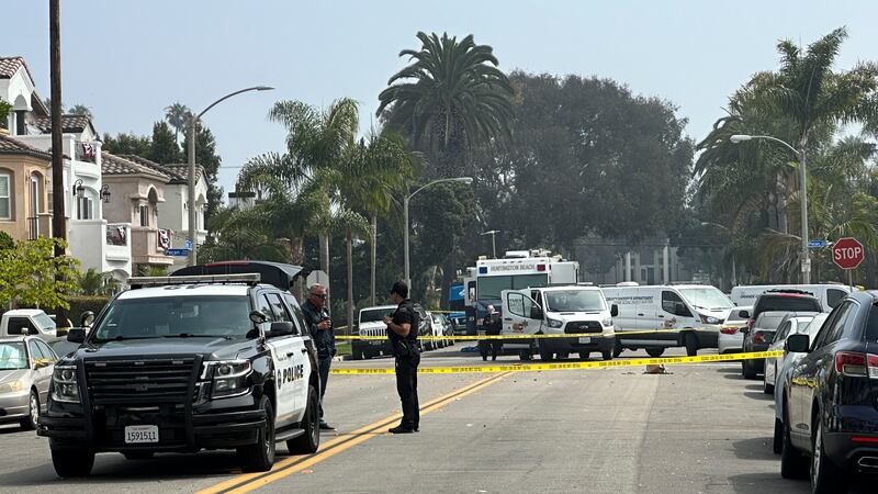 Police officers stand guard at the crime scene where police say two people were killed and...