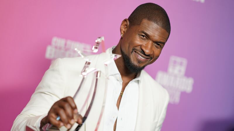 Usher poses with the Lifetime Achievement award in the press room during the BET Awards on...