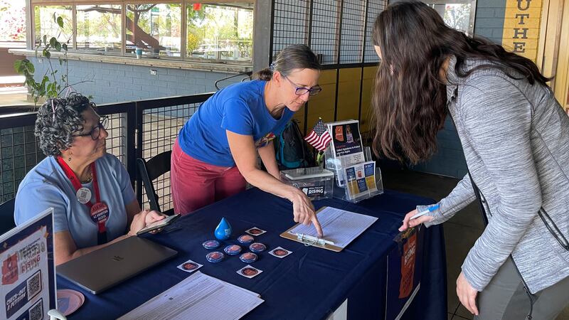 FILE - Volunteer signature gatherers Judy Robbins, left, and Lara Cerri, center, collect Grace...