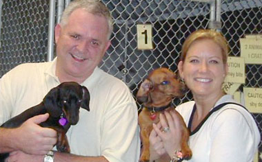 Picture of a man and woman carrying dogs