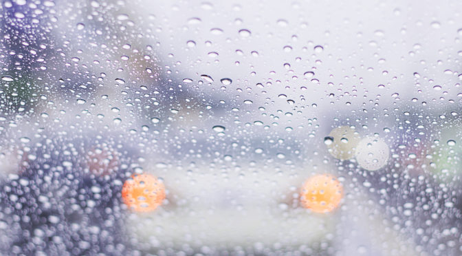 car window covered in rain drops