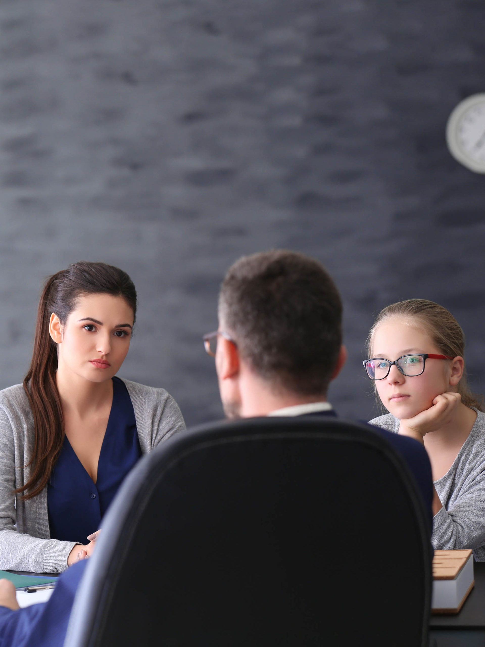 Young woman with daughter during teacher-parent meeting at school