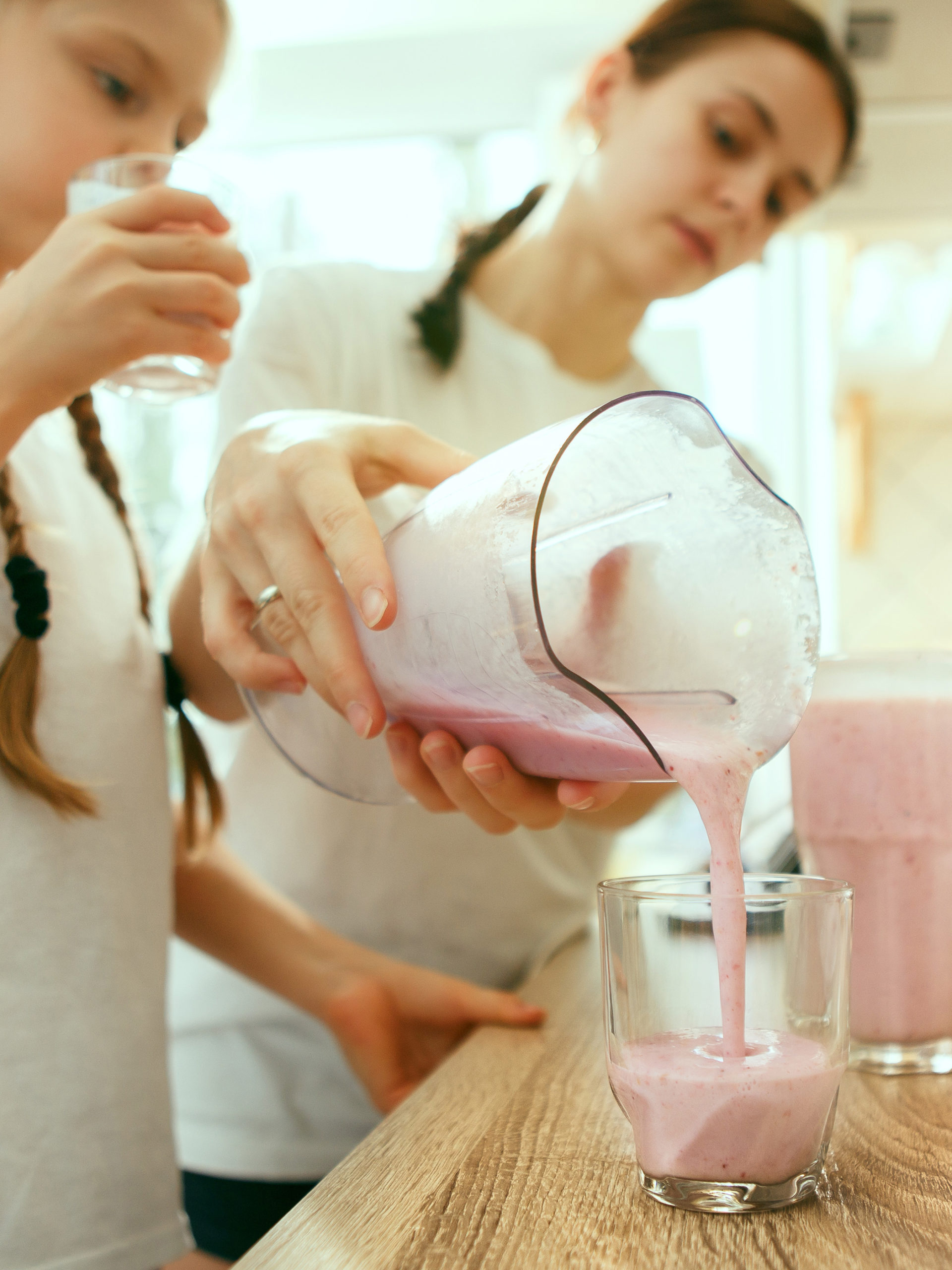 mom and daughter preparing smoothies in the morning for breakfast