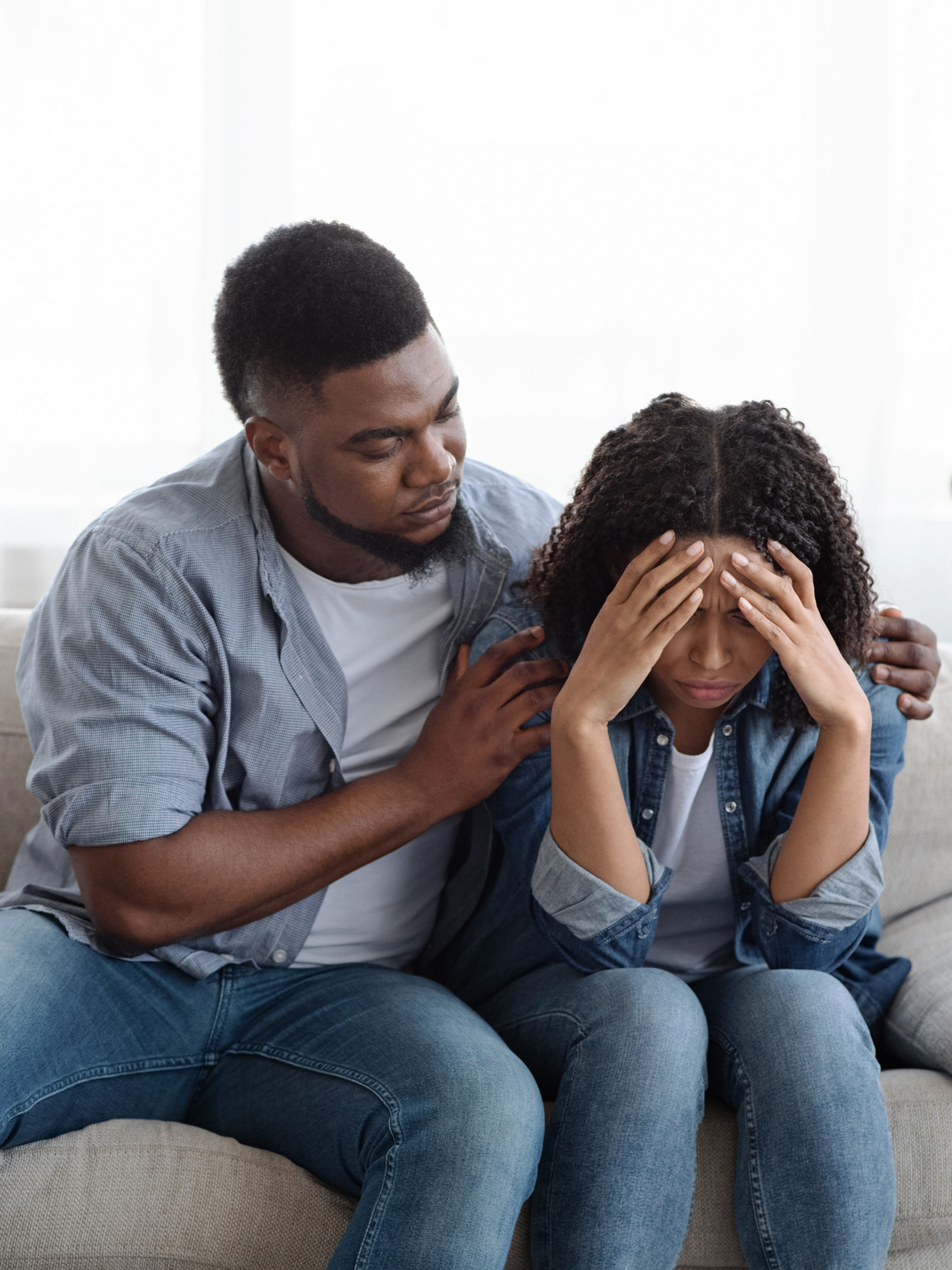 dad comforting distraught teenager with hands on her face