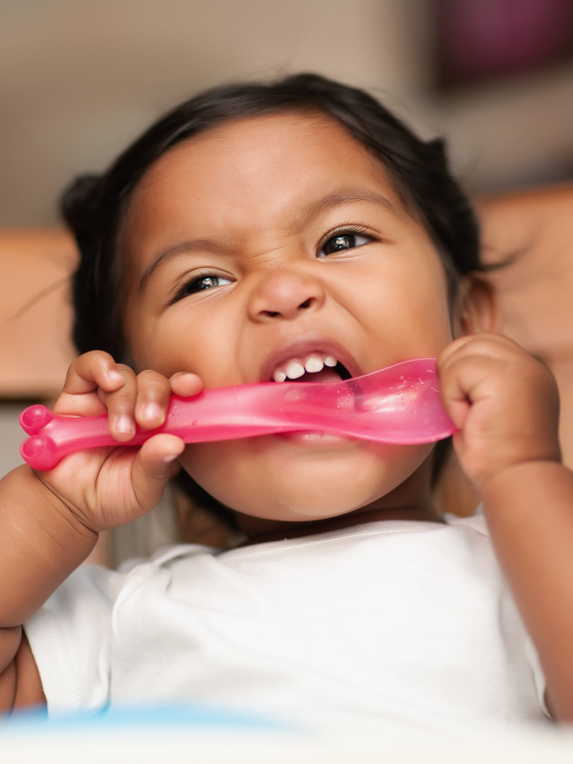 little girl bites her spoon