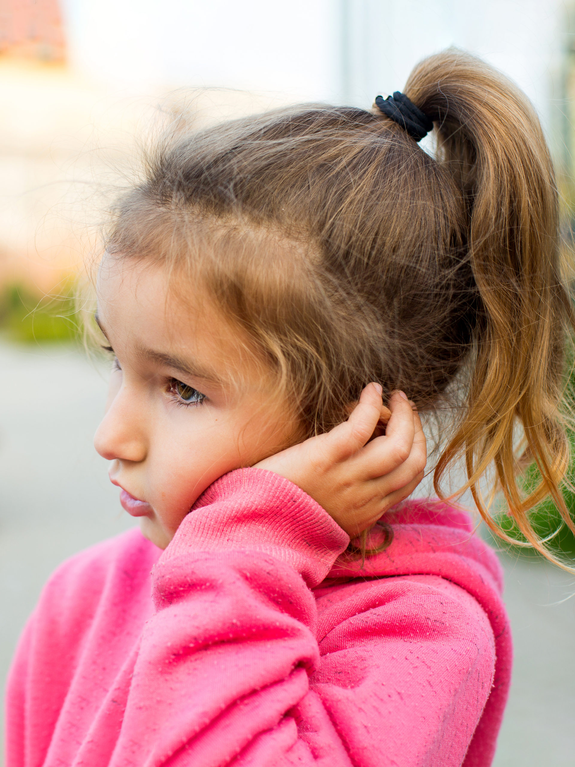 girl holds ear that hurts