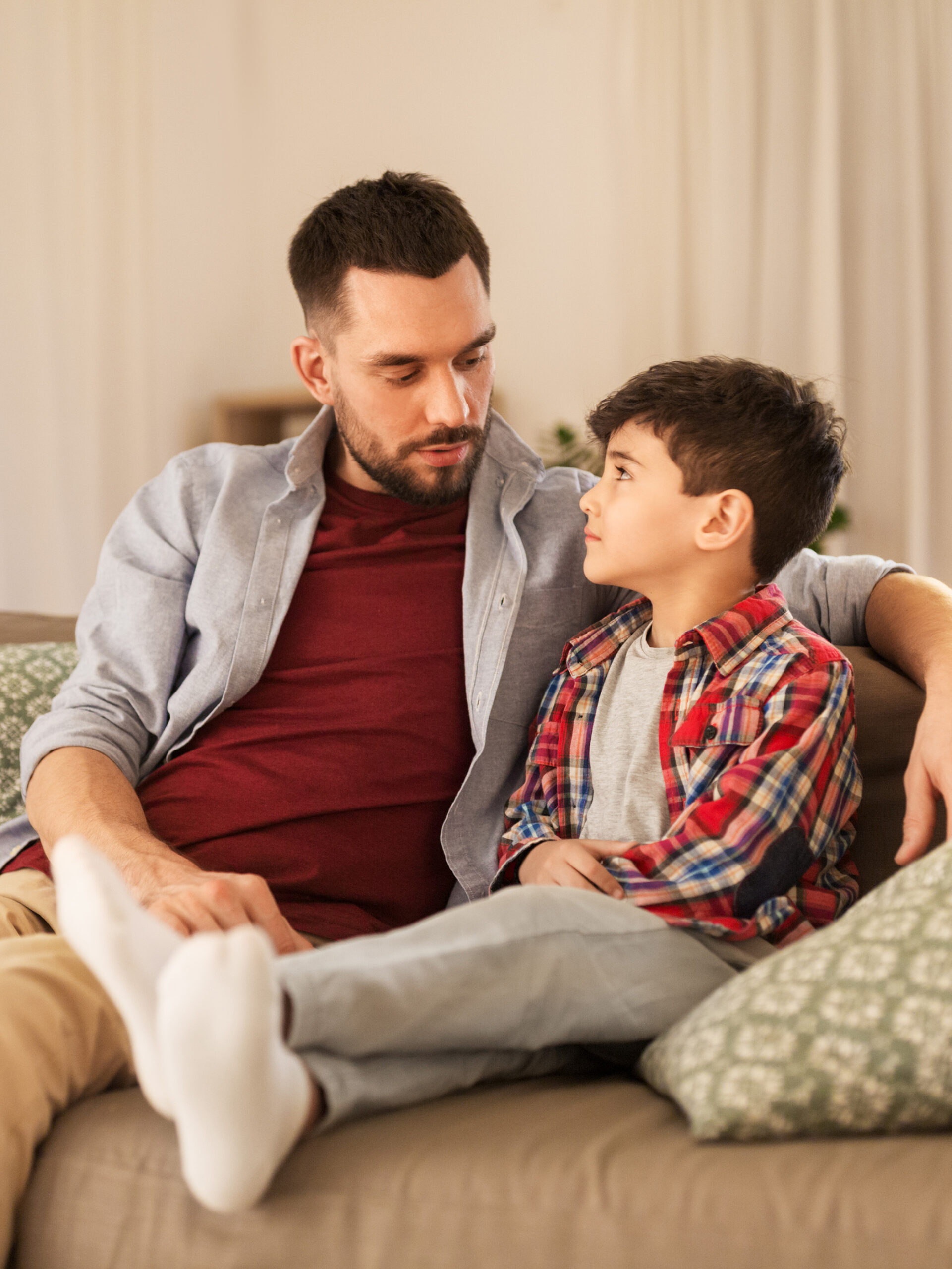 Parent and child sitting on a couch talking about gun safety