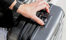 person locking Samsonite suitcase