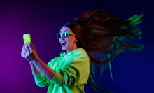 Woman wearing green hoodie and holding green phone