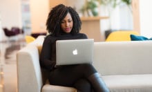 Woman Using Macbook Sitting on White Couch