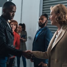 The Doctor shakes hands worriedly with a familiar woman in a business suit. 