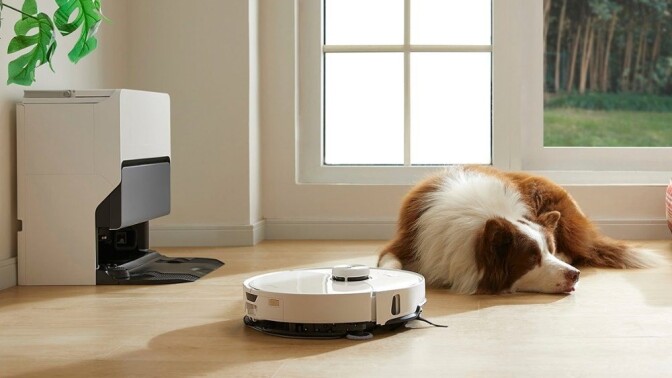 a roborock robot vacuum cleans the floor in front of a sleeping dog