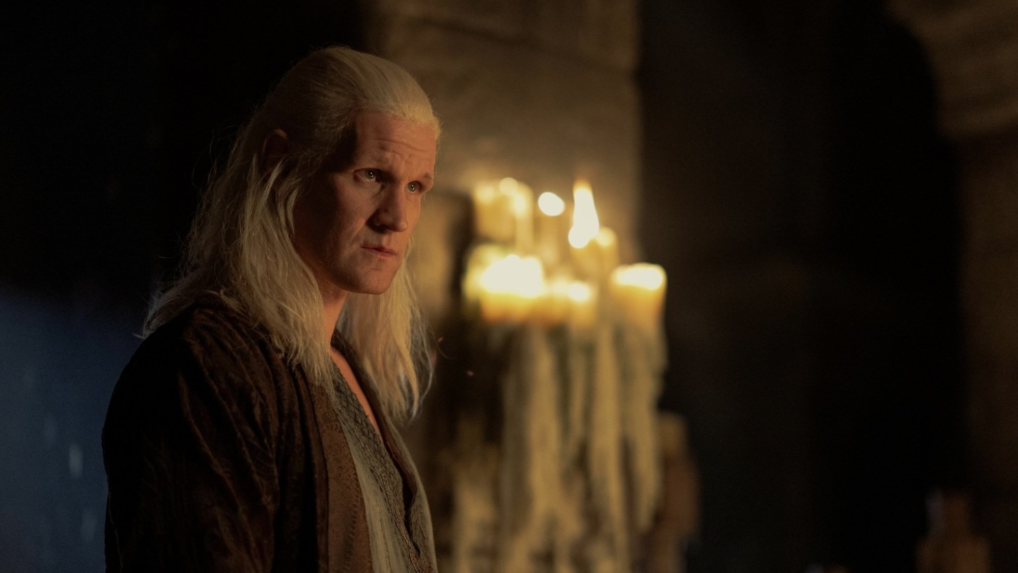 Daemon Targaryen in Harrenhal in his nightclothes, standing in front of a large altar of candles.