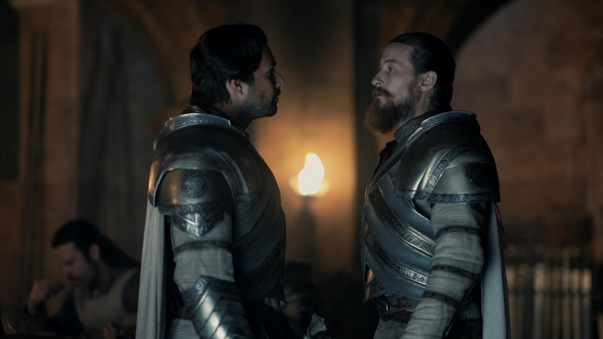 Ser Criston Cole and Ser Arryk Cargyll speak, each wearing armor and a white cloak.