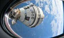 Starliner flying in space while docked at the International Space Station