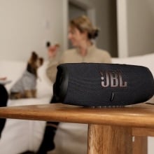 two women sitting on couch with jbl charge 5 speaker