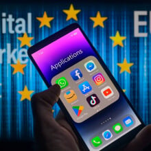 A phone displaying an applications folder in front of the European Union symbol. 