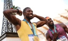  Gold medalist Noah Lyles poses with a miniature Eiffel Tower