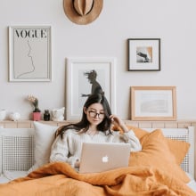 Person in bed looking at computer