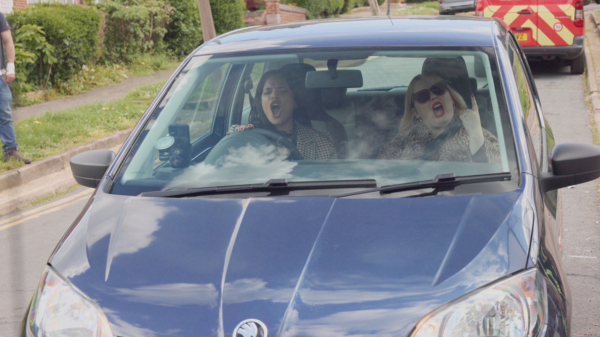 Two women sing loudly in their car.