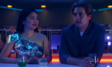 Lana Condor and Cole Sprouse sit at a bar in "Moonshot."