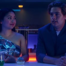 Lana Condor and Cole Sprouse sit at a bar in "Moonshot."