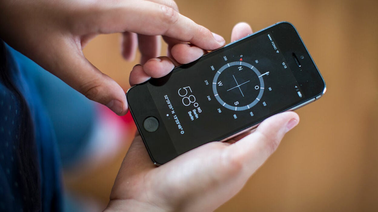 Boy using a compass app on his smart phone.