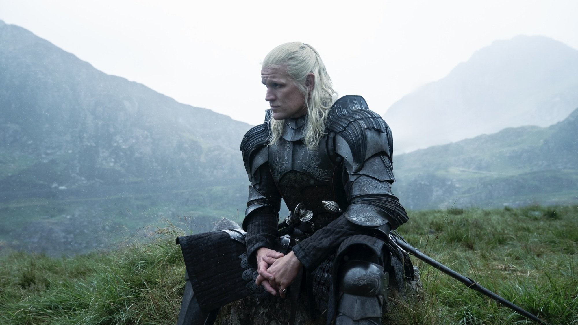 Daemon from "House of the Dragon" sits alone in a green field, wearing a full suit of armor.