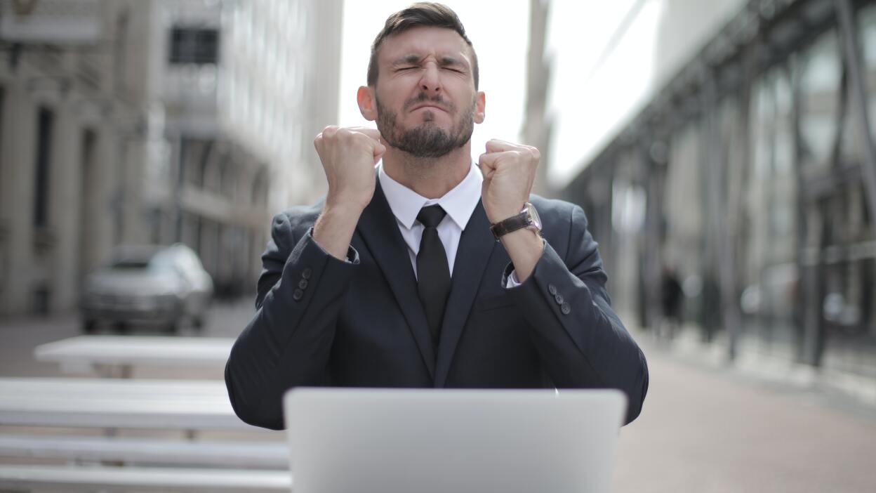 Man grimaces in fron of laptop