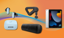 Soundcore earbuds, TheraGun Prime, Soundcore speaker, and iPad with orange background