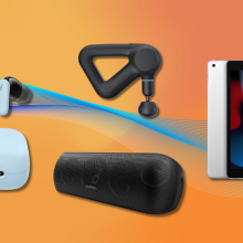 Soundcore earbuds, TheraGun Prime, Soundcore speaker, and iPad with orange background