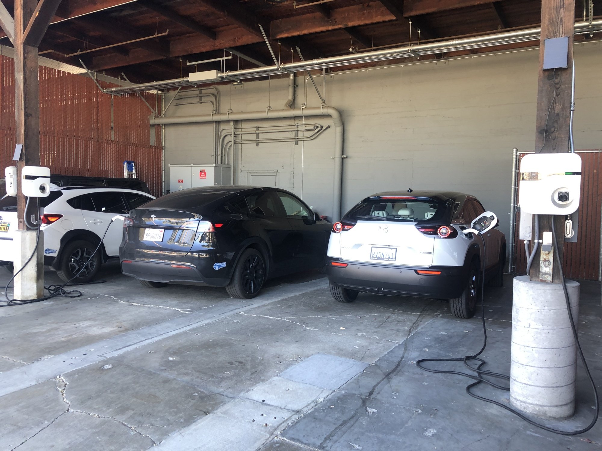 A row of cars plugged in and charging. 