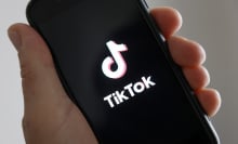 hand holding phone showing tiktok logo