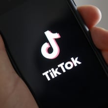 hand holding phone showing tiktok logo