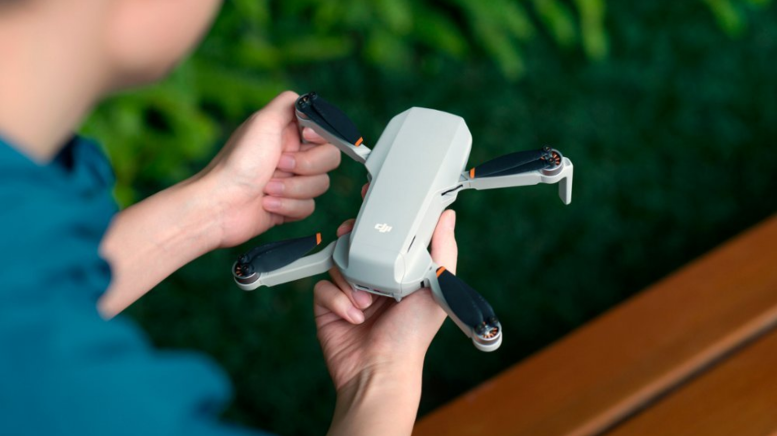 a close-up of a person holding a DJI Mini 4K drone