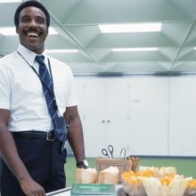 A man (Tramell Tillman as Mr. Milchick in "Severance") rolling a card of honeydew and cantaloupe melon.