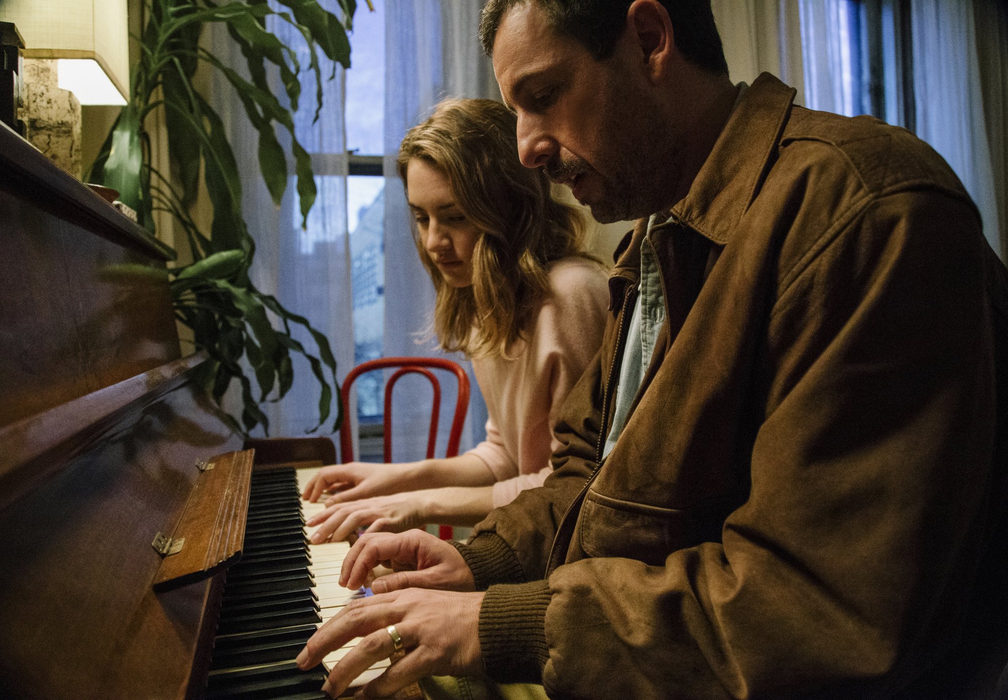 Grace Van Patten and Adam Sandler sit next to each other playing the piano in "The Meyerowitz Stories."