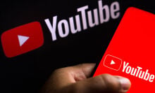 The YouTube logo displayed on a smartphone. 