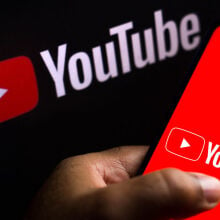 The YouTube logo displayed on a smartphone. 