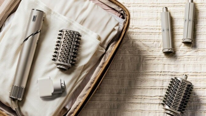 a sharkflex style hair dryer with accessories sits in an open suitcase