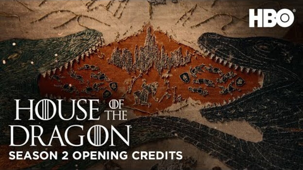 A tapestry of two dragons breathing fire over a castle and soldiers.