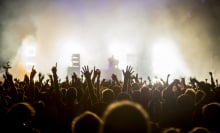 Hundreds of people with their arms in the air at a music festival