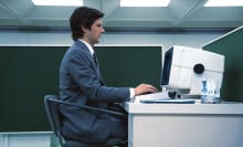 A man at a desk types on a computer.