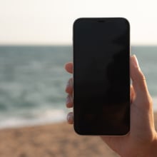 Man holding phone at beach