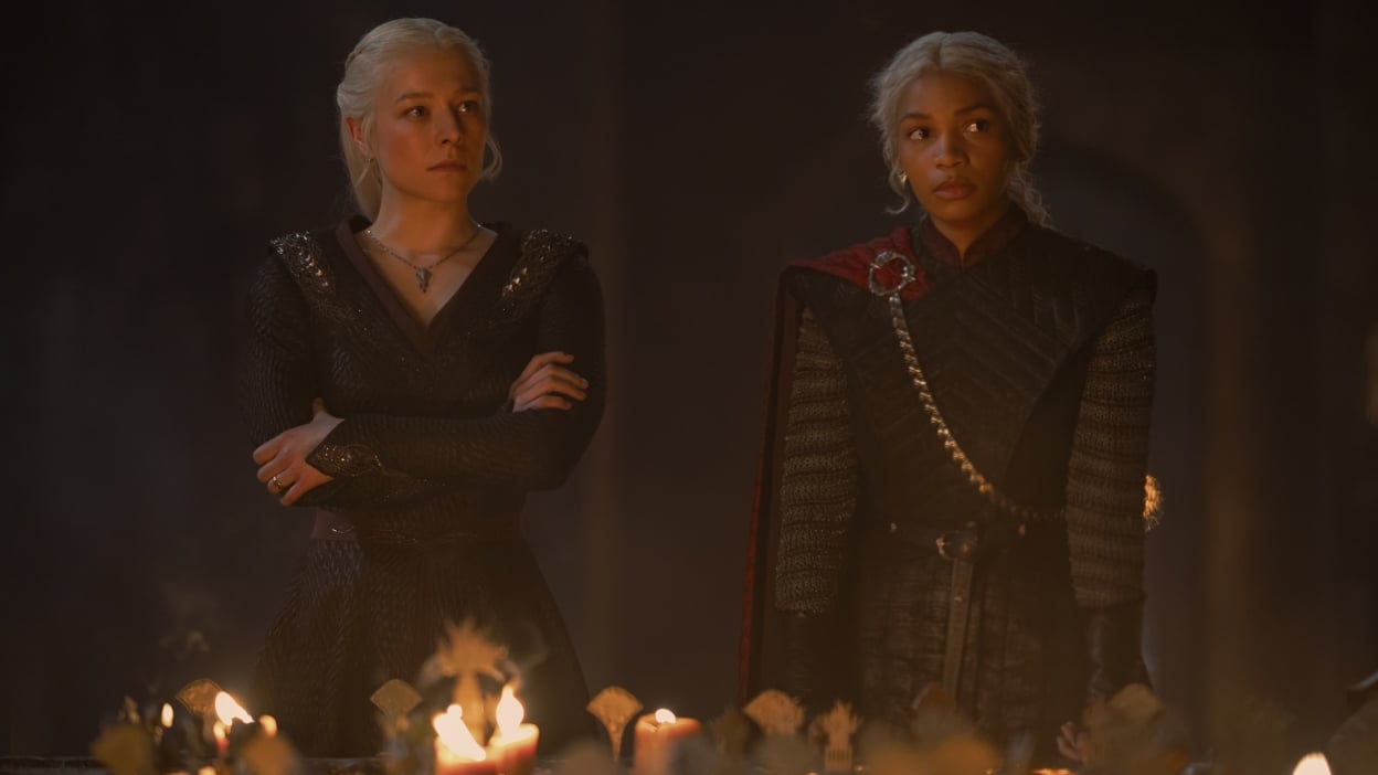 Rhaenyra and Baela Targaryen stand at the head of a war table covered in candles.