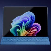 a microsoft surface pro 11 with a keyboard attached against a dark blue background