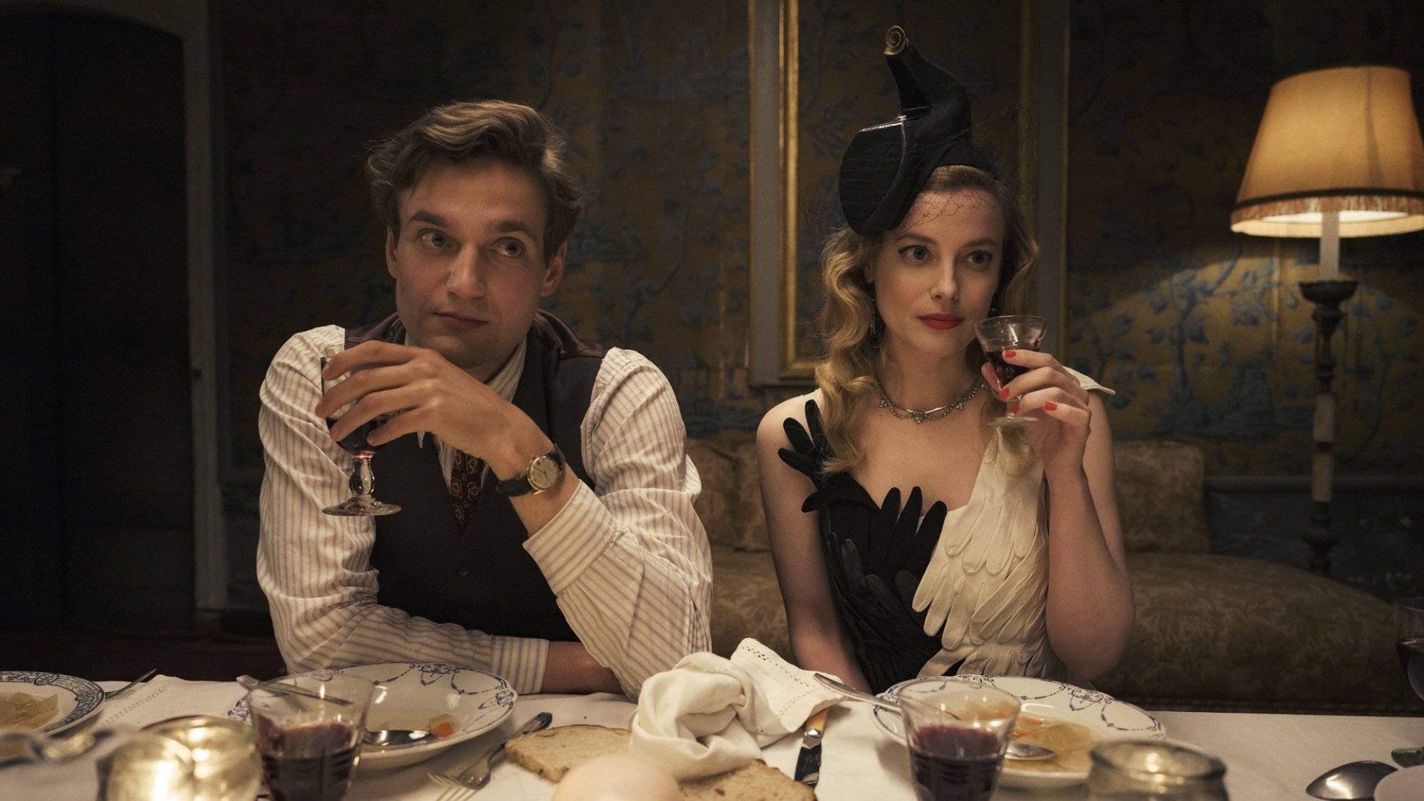 A man and woman in chic attire attend a dinner party.