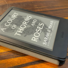 kindle with book cover sitting on table