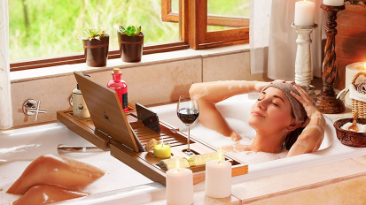 woman laying in bath with bath caddy