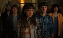 Five of the kids from Netflix's "Stranger Things" series stand in a row, wearing concerned expressions as they stare at something off-camera.